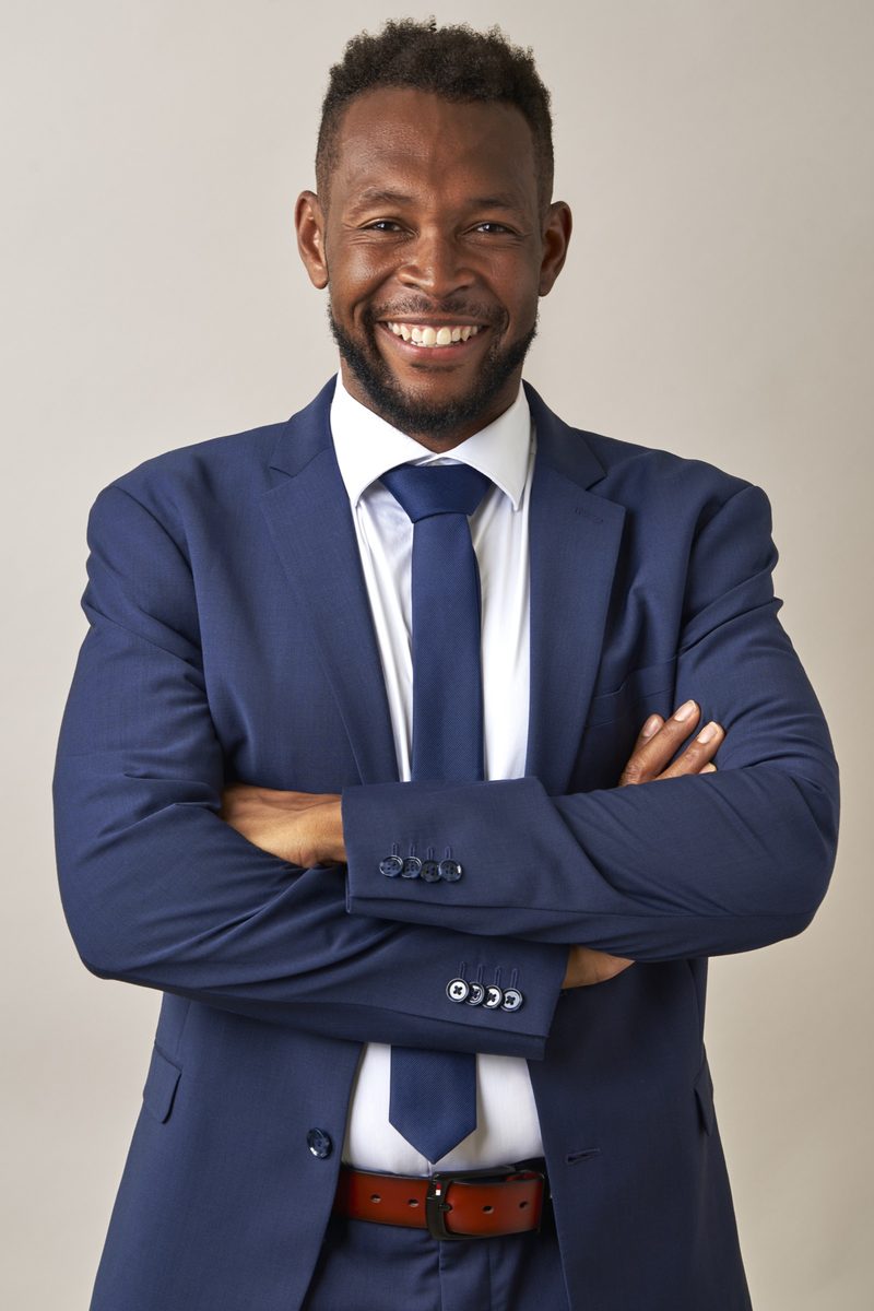Malcolm Alexander-Neal smiling in a blue suit